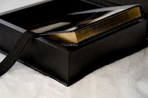A series of black and gold boxes arranged in a diagonal pattern on a white surface creates an elegant display.
