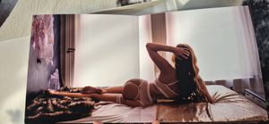 A person lies comfortably on a bed in a sunlit room with white bedding and soft natural lighting.