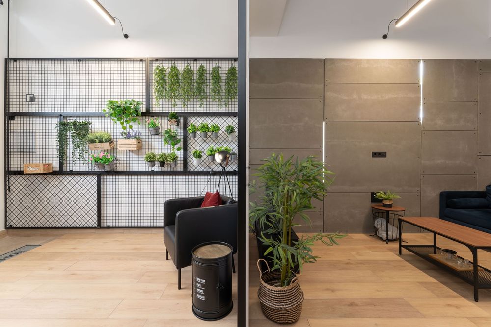 Modern office interior with pegboard wall storage, plants, and wood flooring featuring minimalist industrial design elements.
