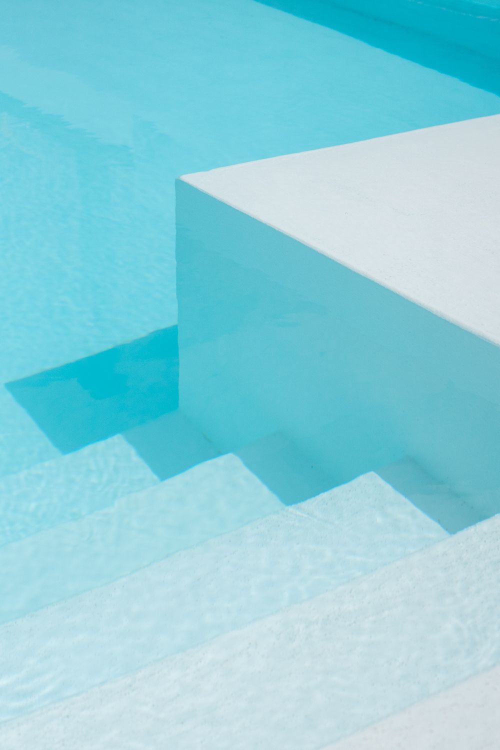 Abstract geometric pattern of turquoise and white shapes creating a minimalist architectural composition.