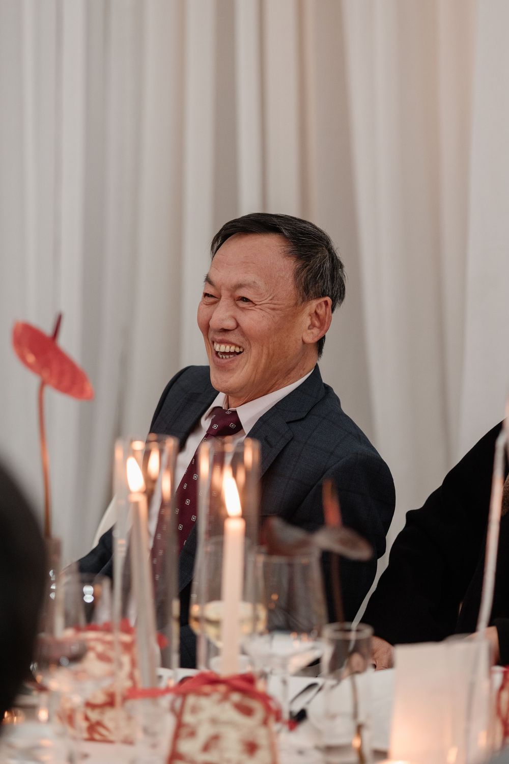 Dad laughing at candlelit wedding reception dinner table at Four Seasons Montreal. Candid Montreal Wedding Photography by Aliza Dworkind.
