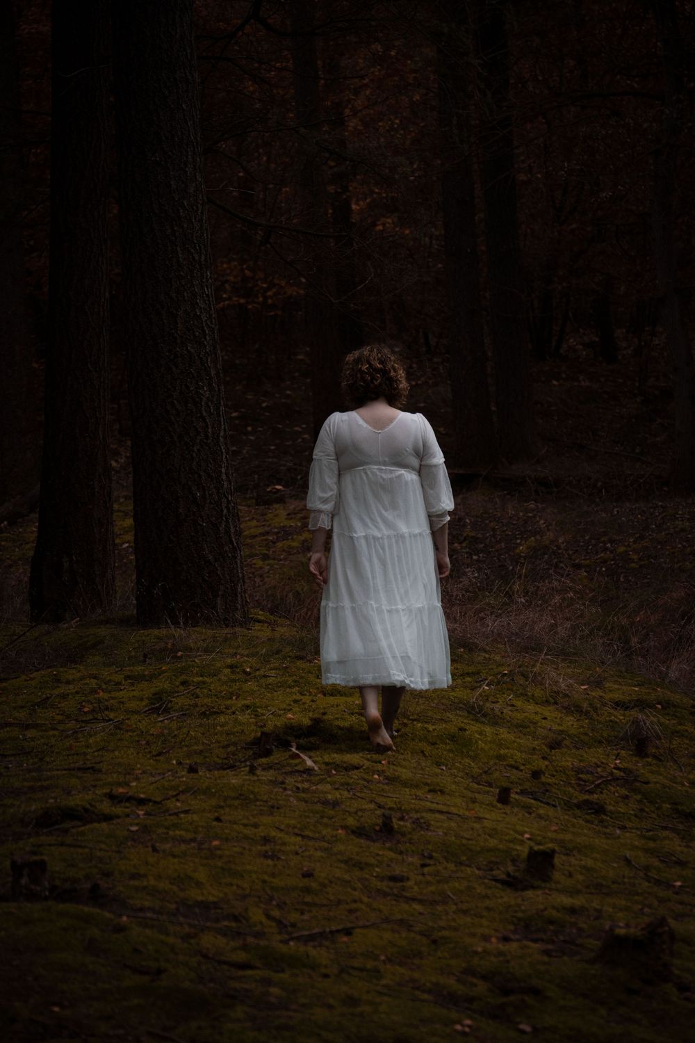 person walking away in the woods