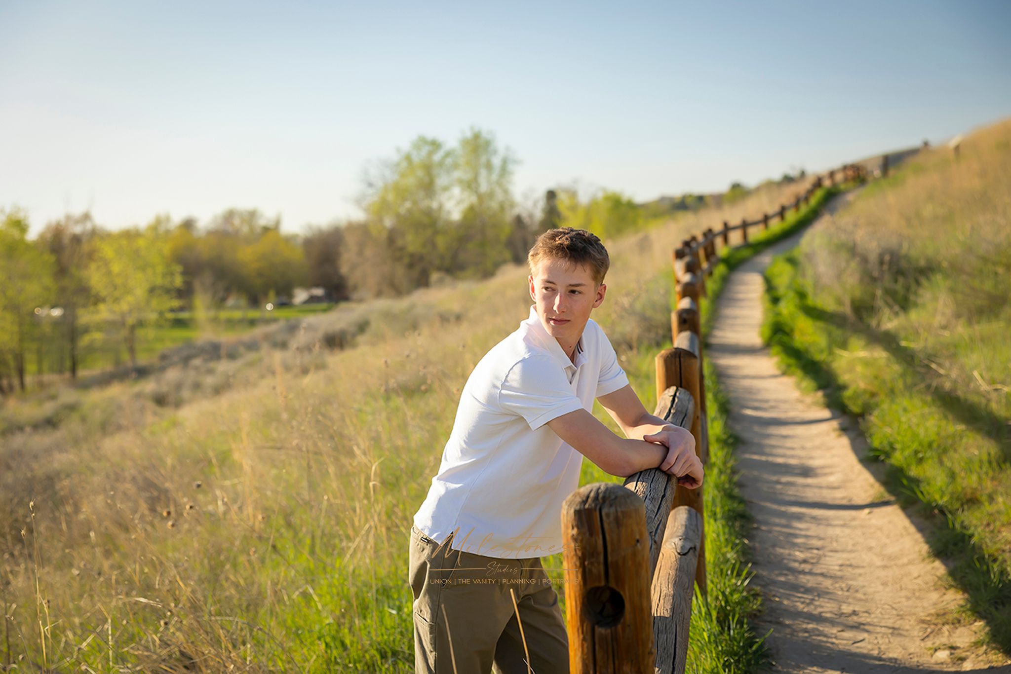 Senior Pictures guy leaning on wood fence milestones portraits