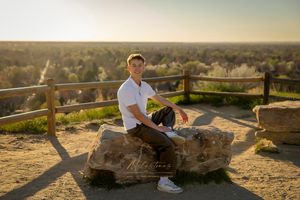 Senior Pictures guy sitting on rock with valley in distance milestones portraits