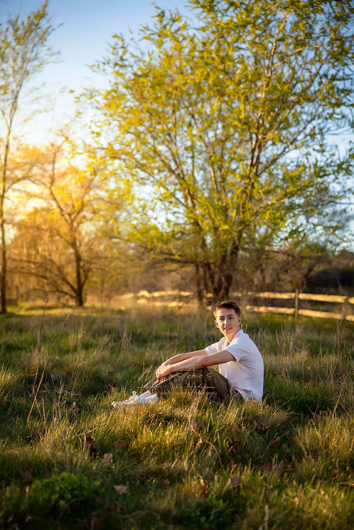 Senior Pictures guy sitting in meadow at golden hour milestones portraits