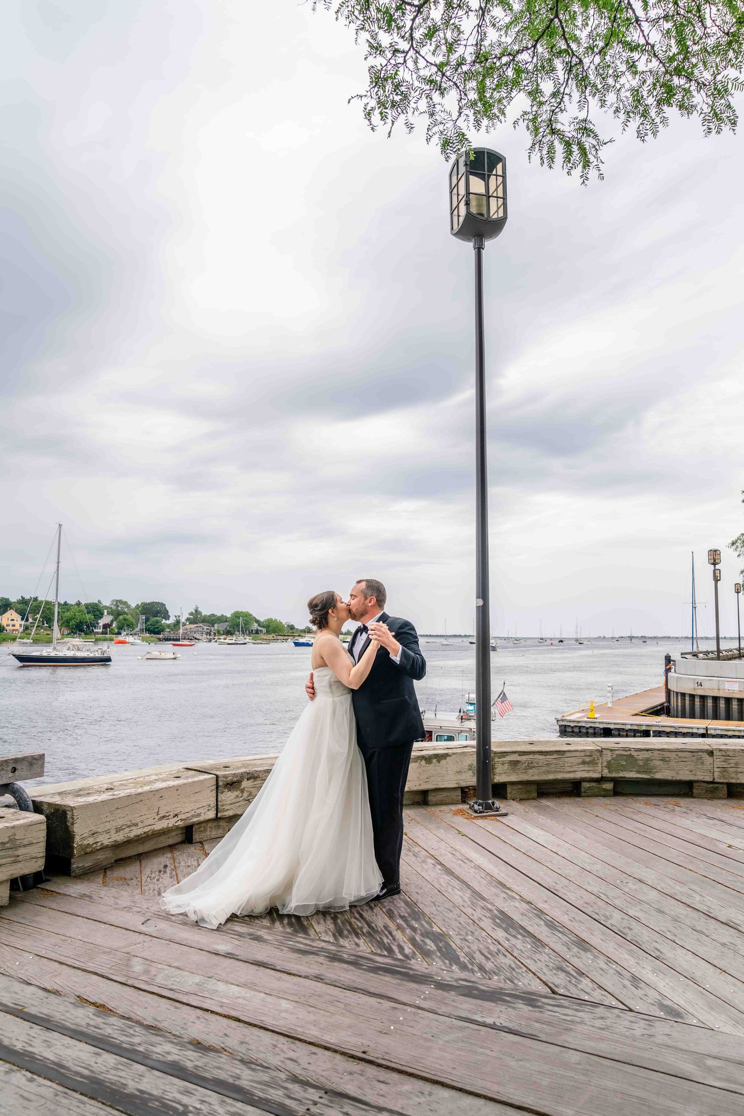 Eloping couple kissing on the Newburyport waterfront in Newburyport, MA.