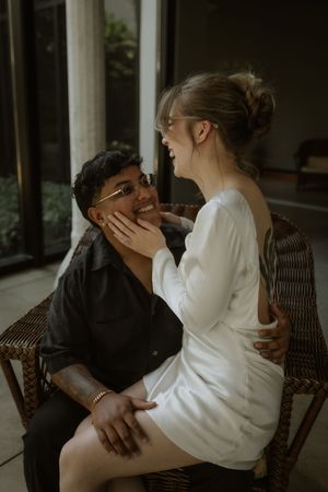 Intimate couple sharing a tender moment while sitting together on a chair for their engagement photos in a Winter Park museum in Florida