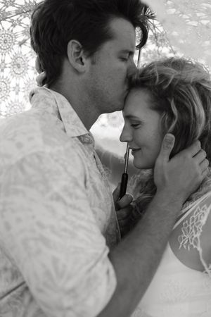 A romantic black and white photo series showing a couple in an intimate embrace against a light textured background.