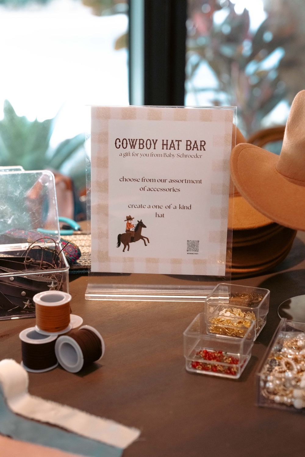 Cowboy Hat Bar station at Baby Schroeder shower with accessories, beads, and trim for custom hat decorating.