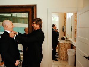 A series of candid photos showing people in formal attire interacting and conversing in a light-colored interior hallway.