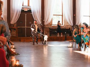 Couples dance together in a rustic ballroom with large windows and flowing white curtains during a wedding reception.