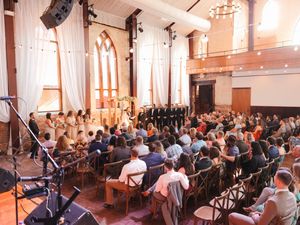 Large wedding ceremony space with rows of chairs filled with guests in a bright, airy venue.