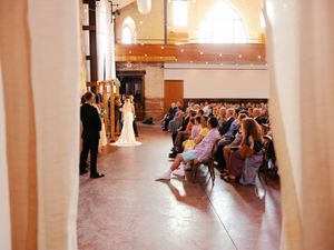 Panoramic view of a wedding ceremony venue with natural light streaming through tall windows.