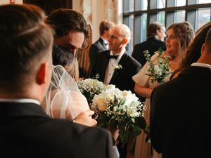 Intimate wedding moment captured in warm lighting at an indoor venue.