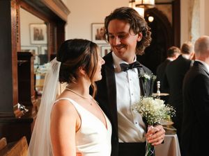 Elegant wedding party dressed in formal attire with white floral bouquets.
