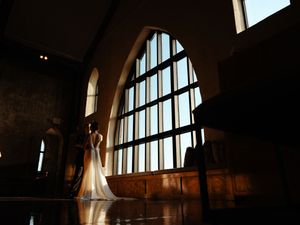 Dramatic silhouette wedding photos against arched windows.