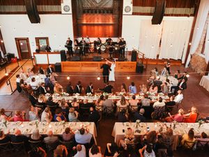 Overhead view of wedding reception setup with tables and chairs in an industrial-style venue.