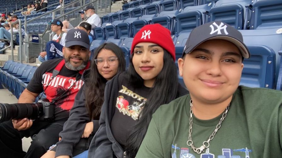 Group of sports fans watching a baseball game from stadium seats.
