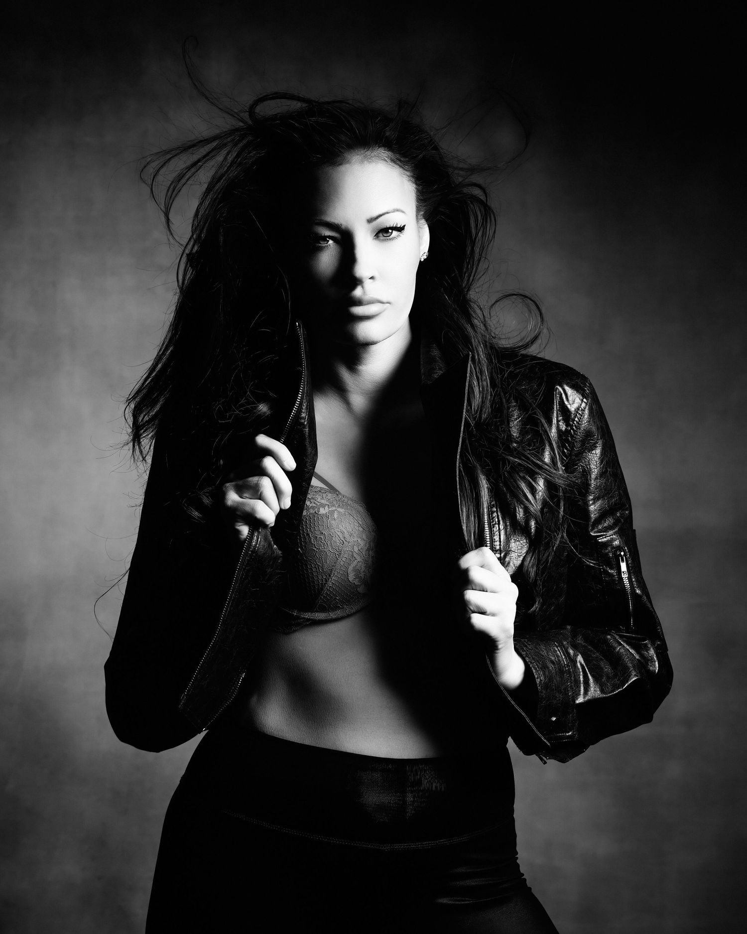 David G Holt Photography - Dramatic black and white photo of a woman in leather jacket with flowing dark hair.