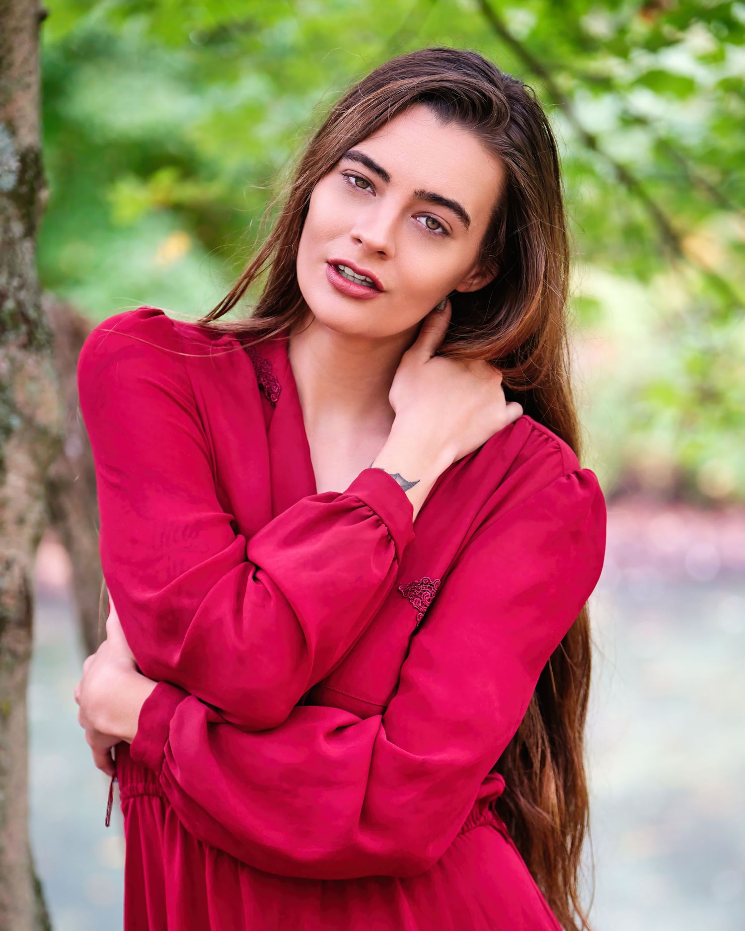 David G Holt Photography - Portrait of woman in vibrant red dress posing outdoors with natural background.