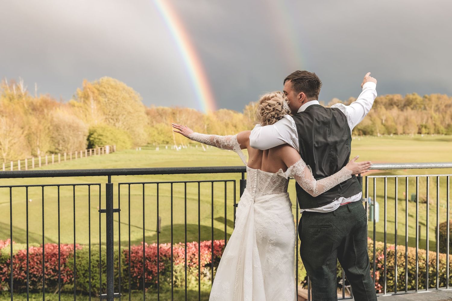 Natural couple moment on their rainy wedding day when a rainbow came out.