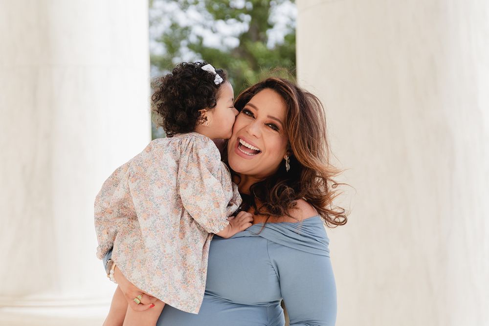A mother and young daughter share tender moments together in a series of candid outdoor photos.