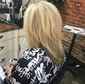 Multiple angles of a platinum blonde bob haircut styled in a salon with exposed brick walls.