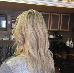 Multiple views of blonde wavy hair with balayage highlights styled in a salon setting.