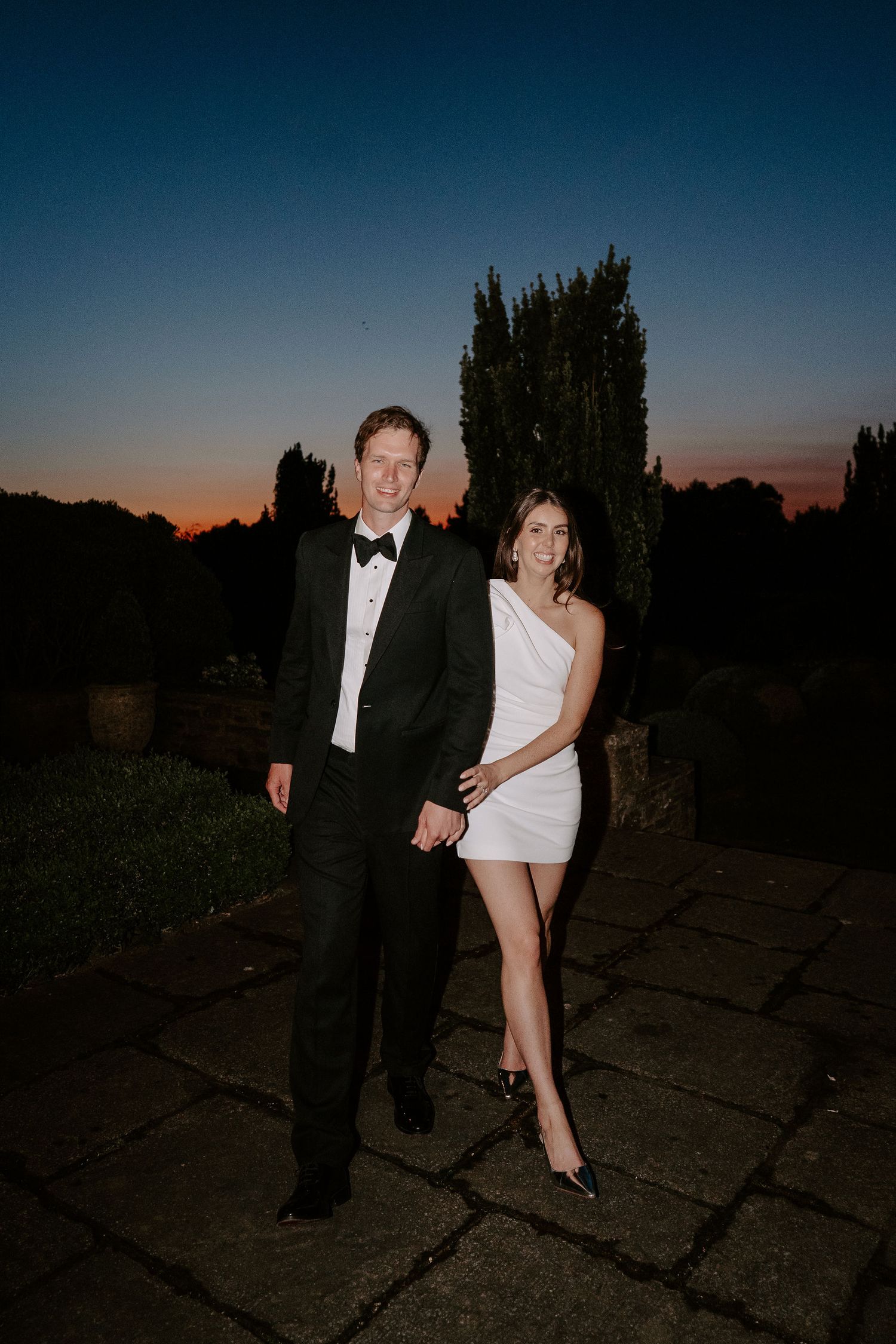 bride and groom smiling with the last of the sunlight setting on the horizon at dewsall court in herefordshire