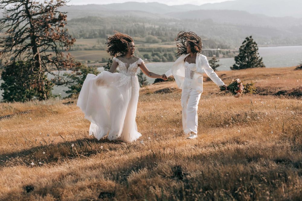 Ellensburg, WA wedding couple walking on tall brown grassy scene with Columbia River in the background.