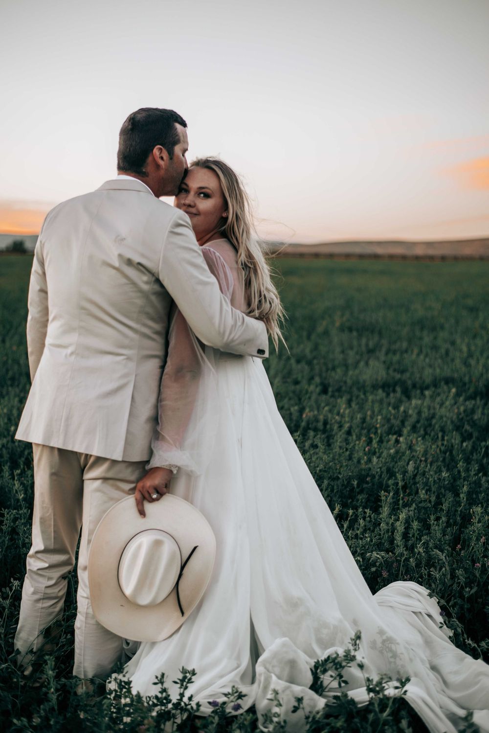 Ellensburg, WA wedding couple kissing in green pasture.