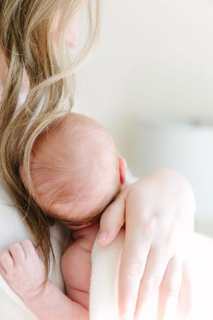 Close-up artistic portrait showing strands of blonde hair falling across face in soft natural lighting.
