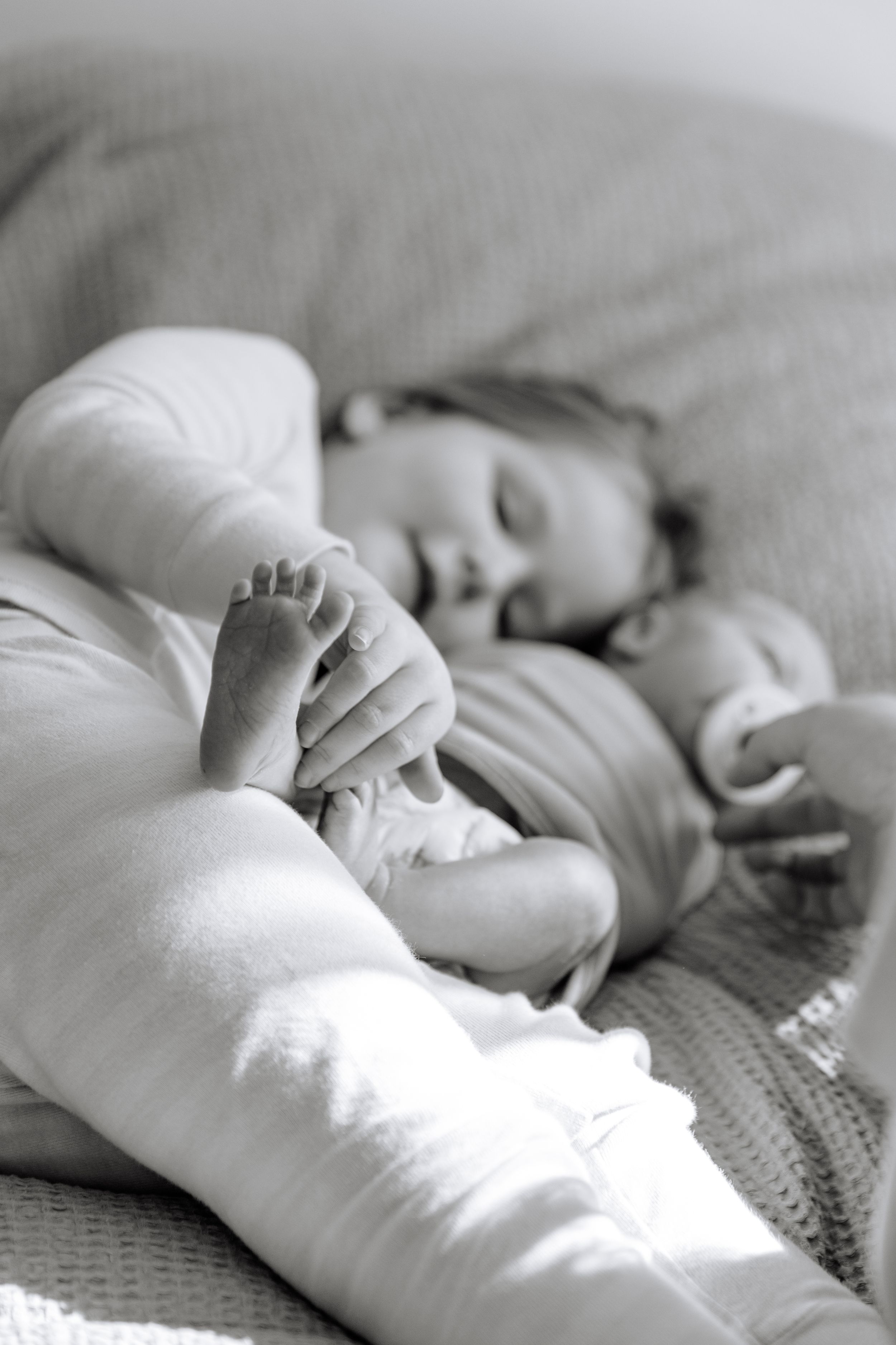 Black and white photo series capturing close-up details of a sleeping baby's hands and face.