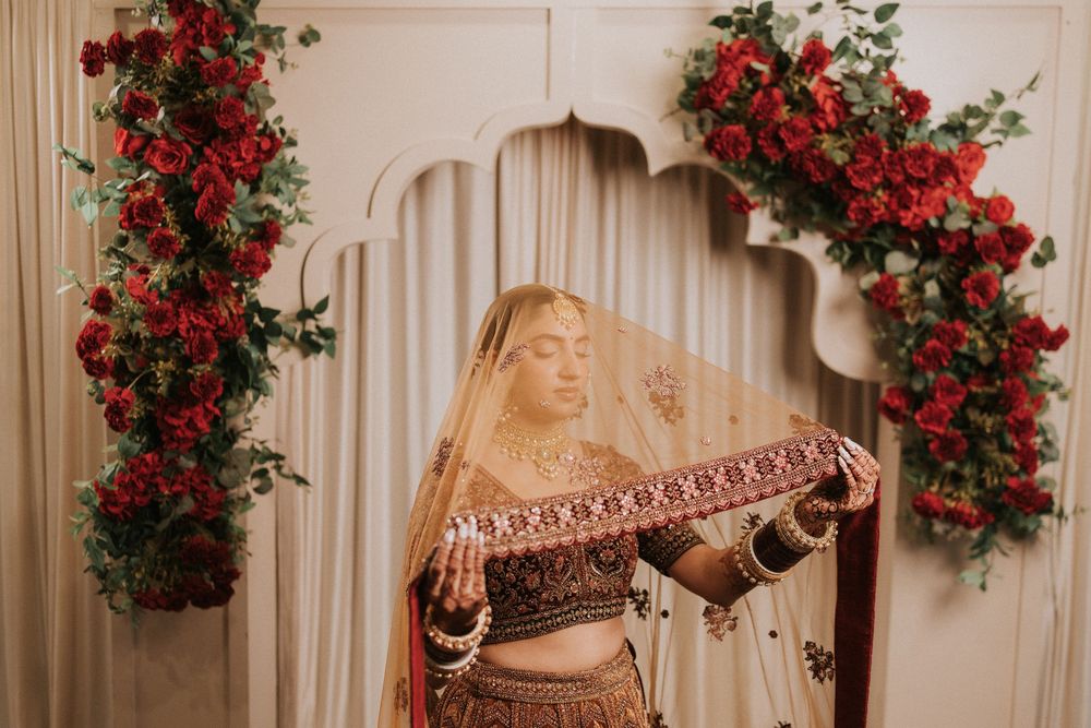 Red roses and floral arrangements decorate a rustic wooden backdrop with vintage decor elements.