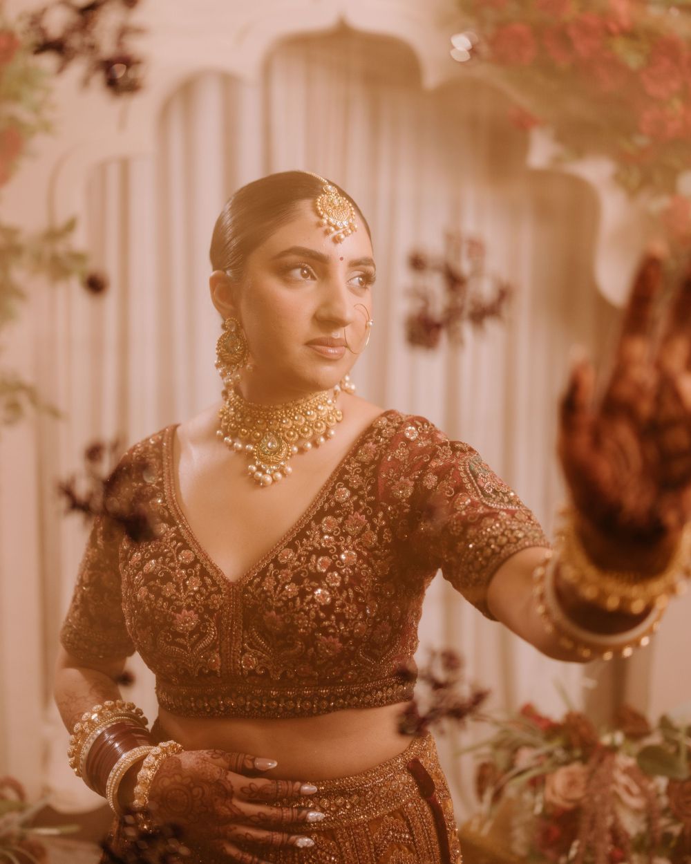 Close-up details of traditional Indian bridal jewelry and embroidered clothing in warm tones.