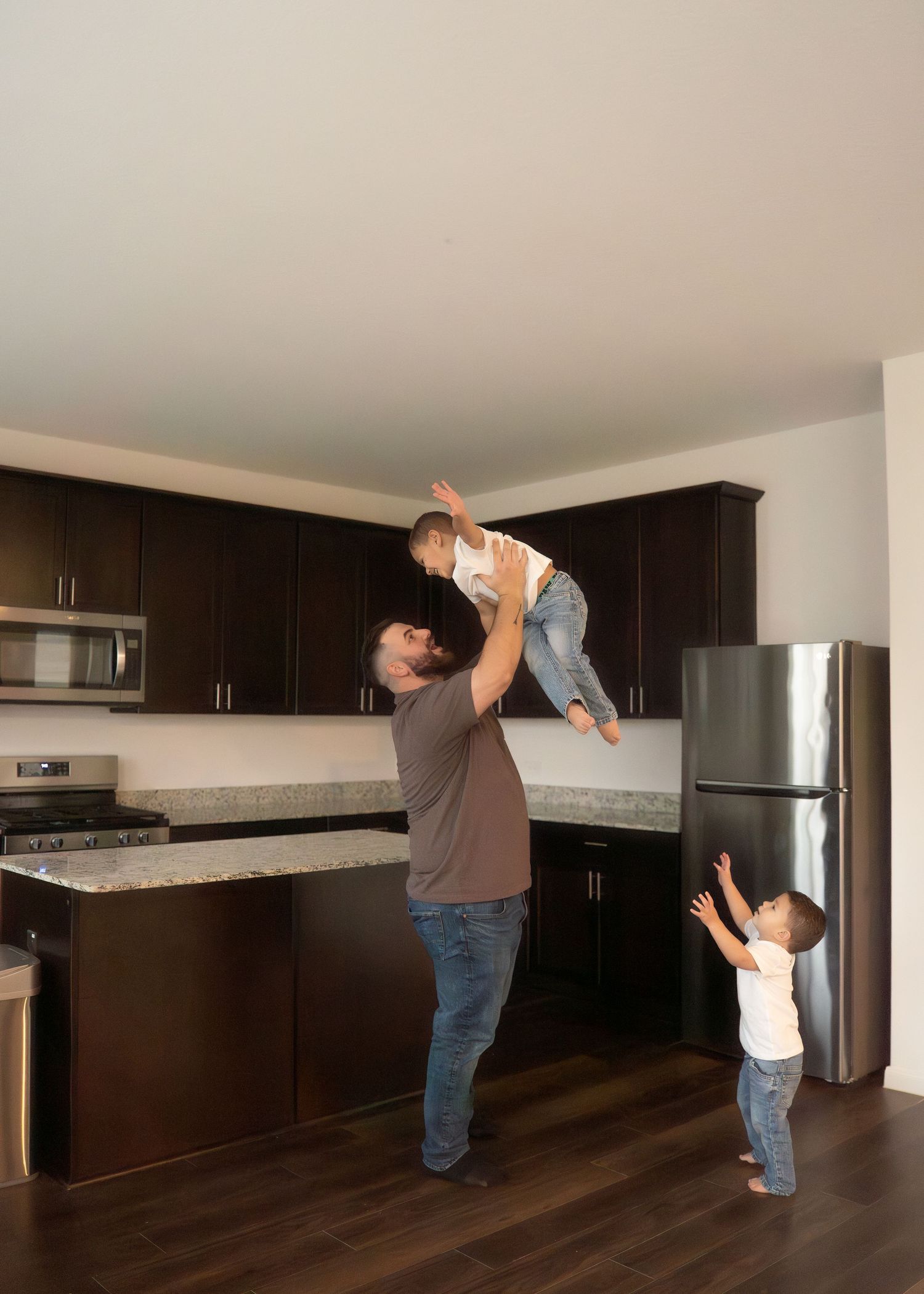 The Emerson Family of five posing in their empty new home, smiling and exploring their new space together