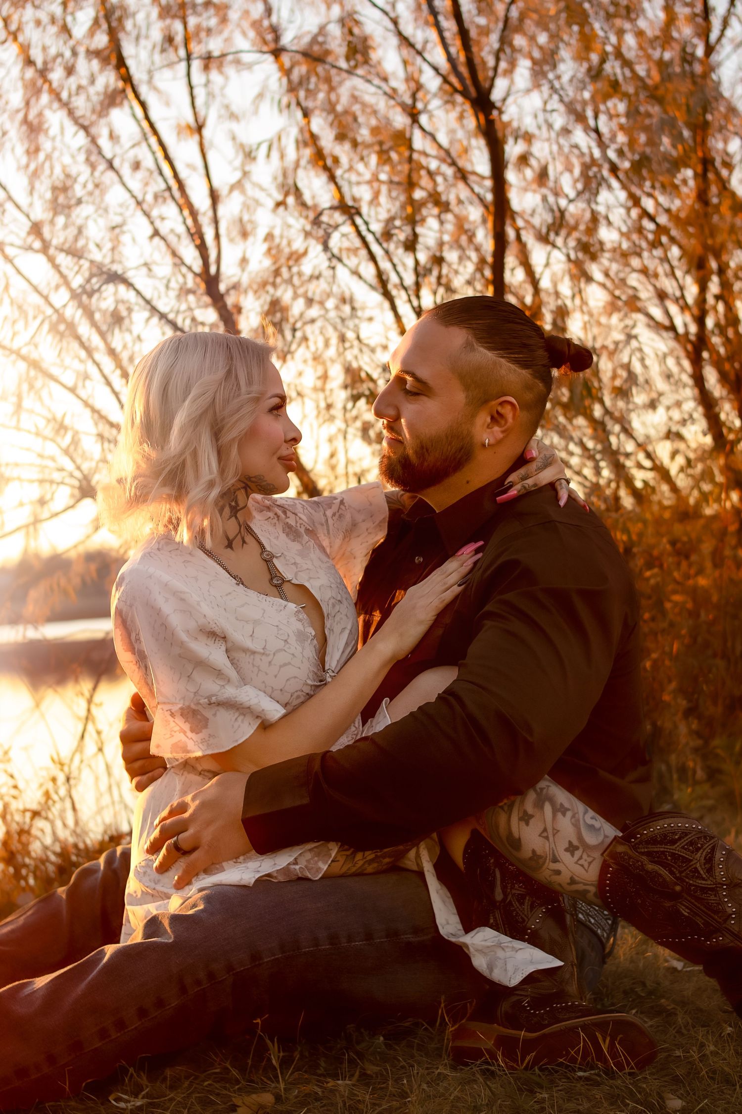 Romantic couple cuddling and laughing together during sunset photoshoot in Williston, North Dakota.
