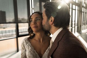 Sunlight streams through windows as a couple shares a romantic moment in an indoor setting.