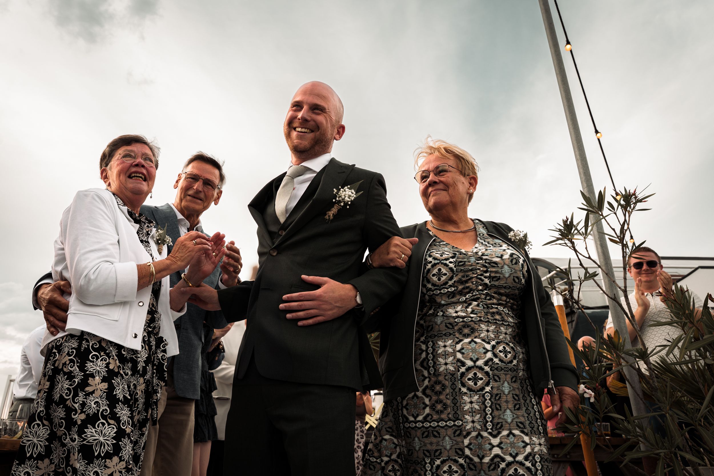 A sequence of black and white wedding reception photos showing guests celebrating and laughing together.