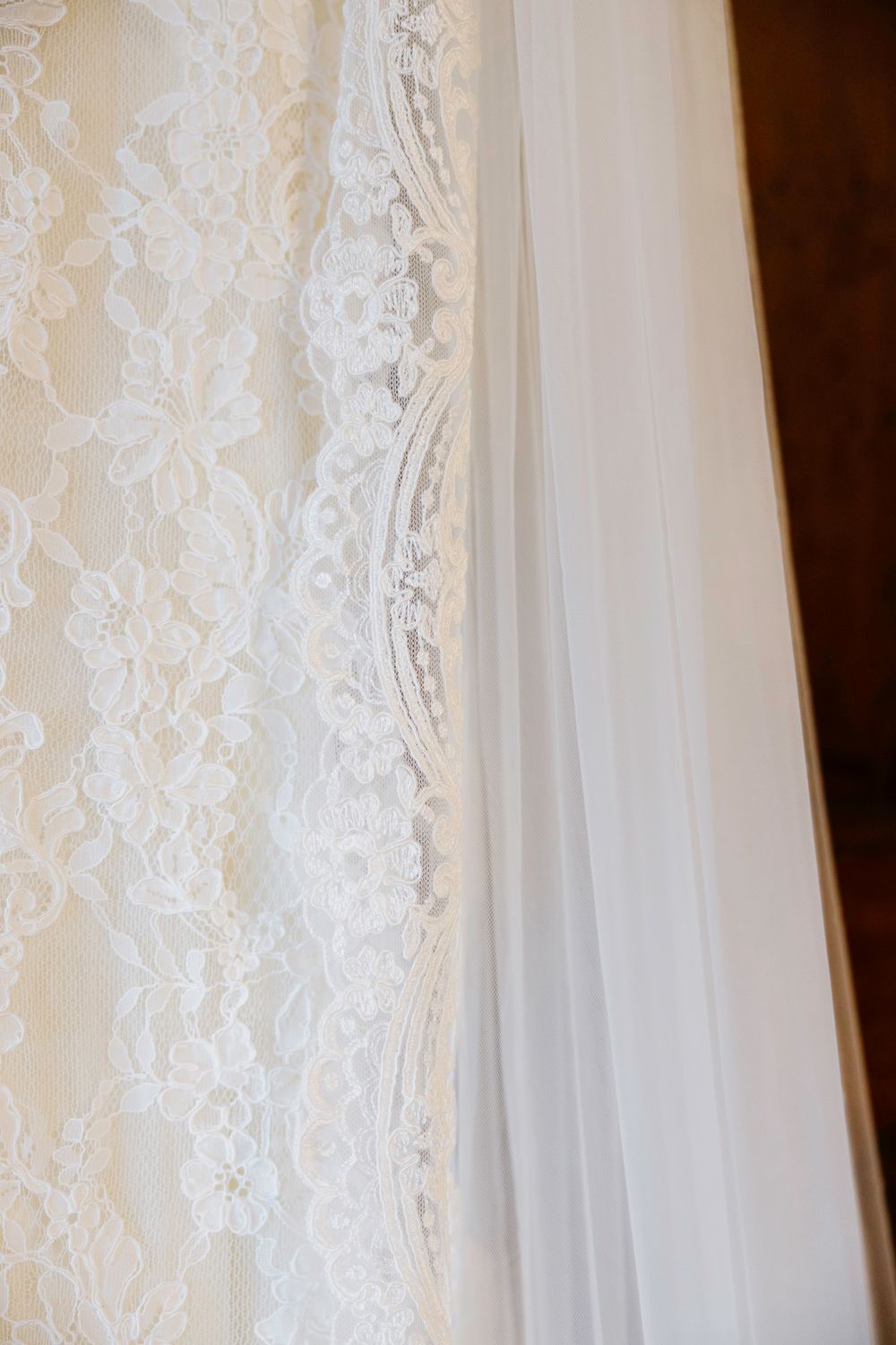 Close-up of delicate white lace curtains with intricate floral patterns creating an elegant translucent effect.