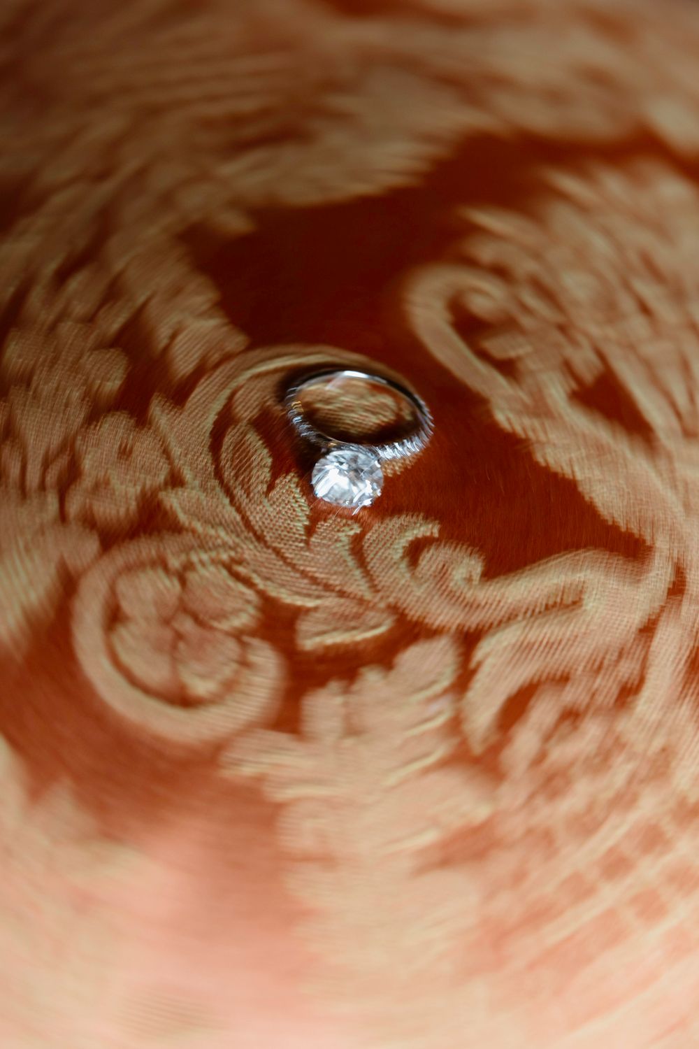 Close-up sequence showing a diamond engagement ring being placed in a spiral seashell.
