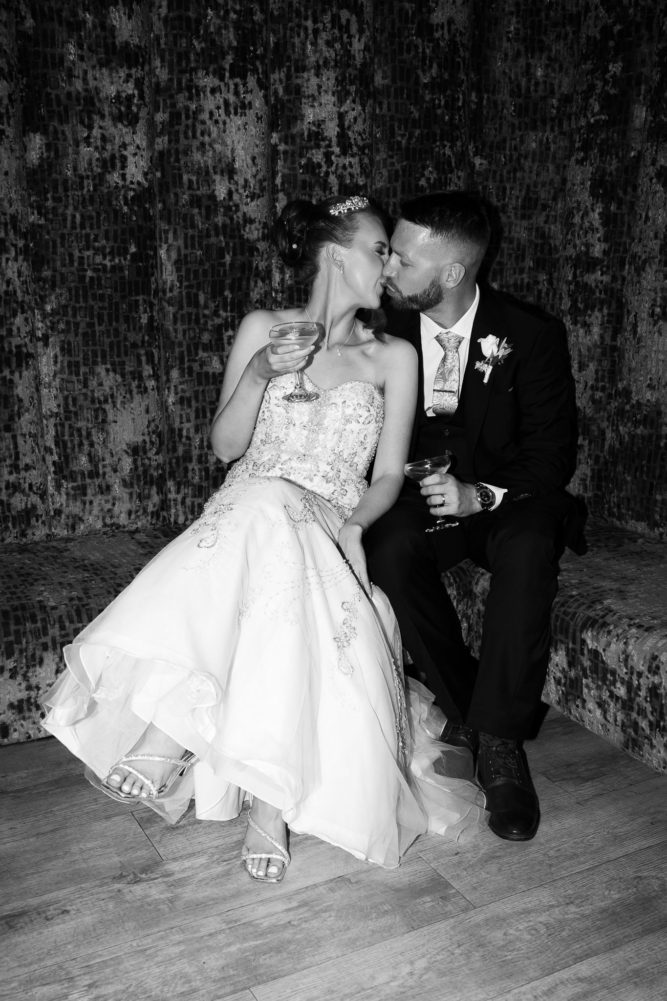 Couple sharing drinks on the floor in formal wedding attire. Woodhill Hall.