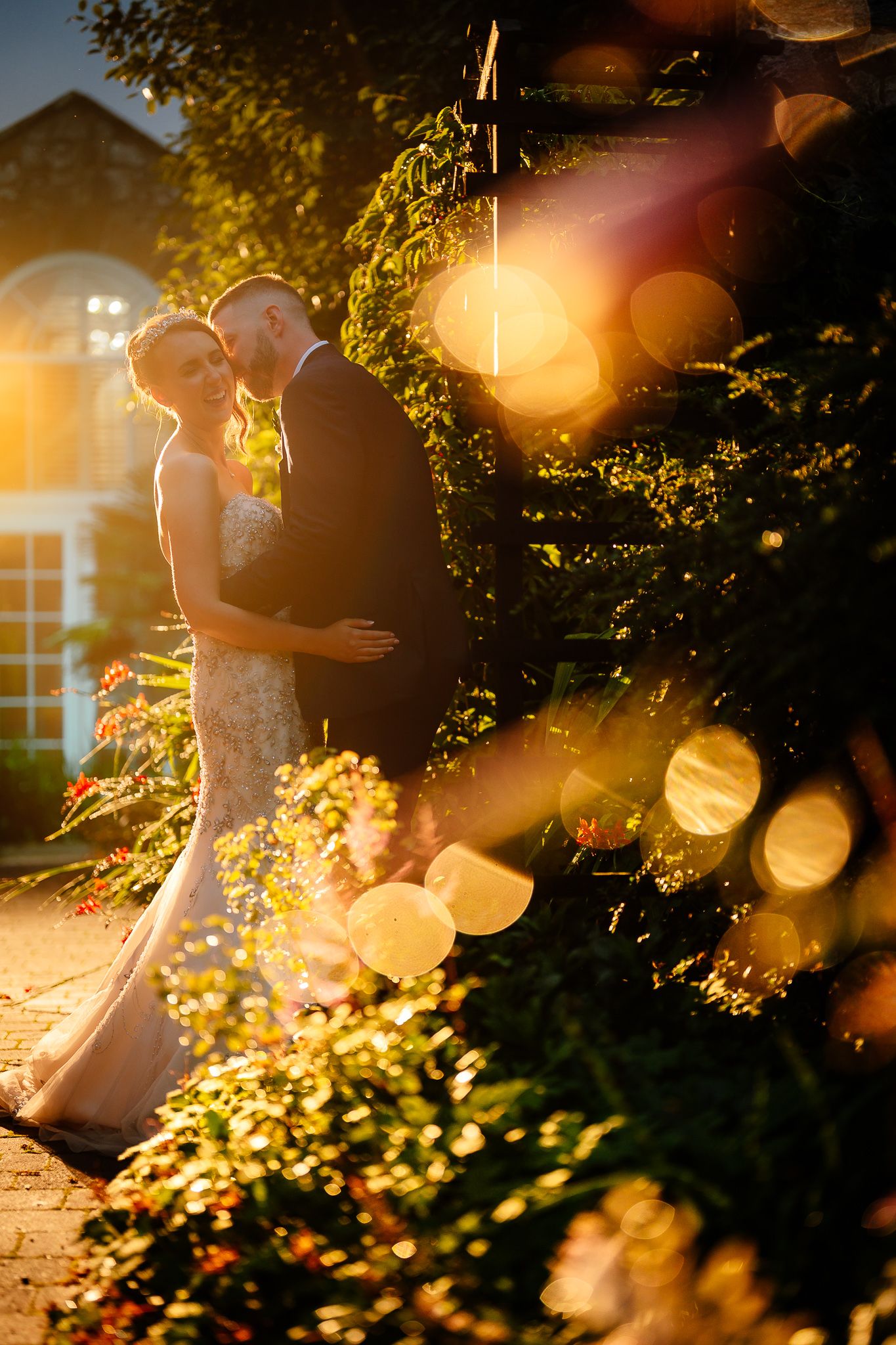 Romantic golden hour wedding photos with sunlight filtering through trees. Woodhill Hall.