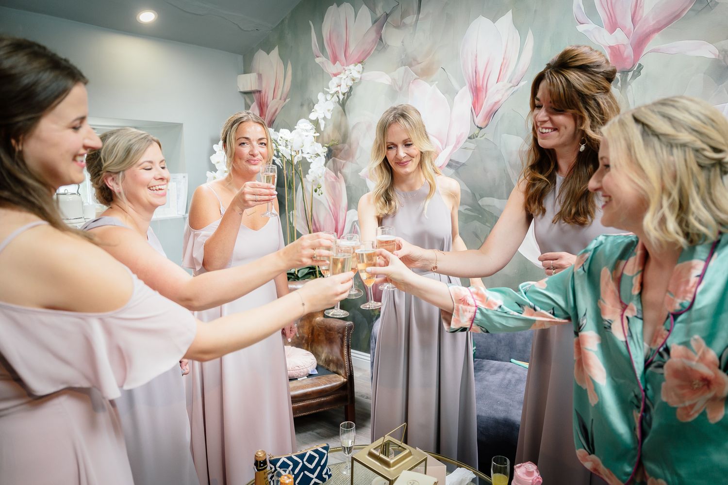 Wedding preparation scene with robes and pink floral decorations in a bright room. Woodhill Hall.