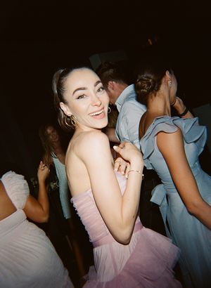 Partygoer in a pink tulle dress dancing at an elegant evening event.