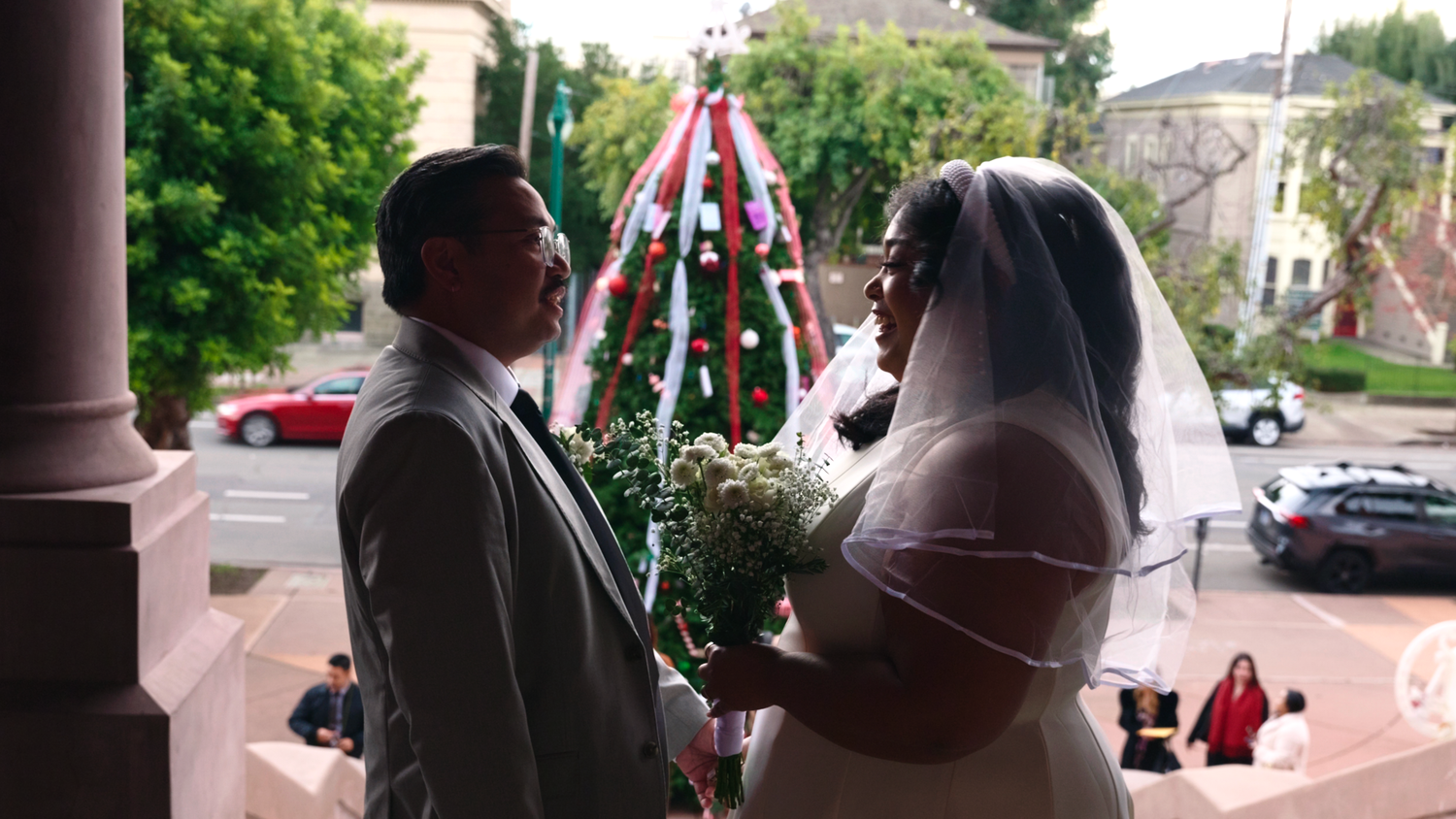Two individuals get ready to get married. Atop the steps of Alameda city hall, they away for the ceremony to begin.