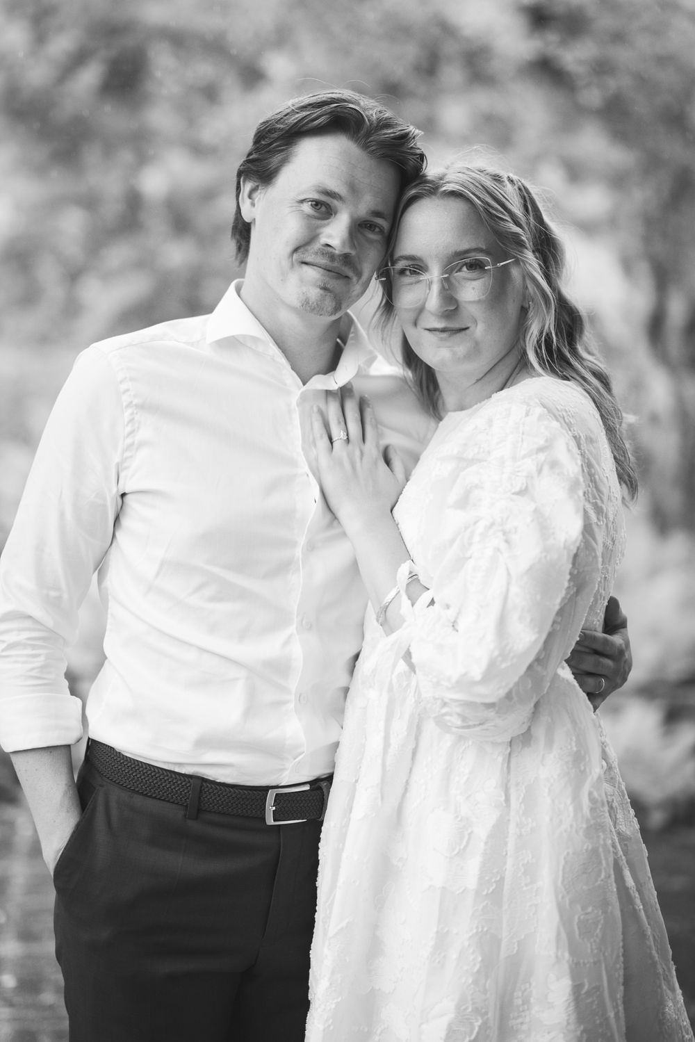 A romantic black and white photo series showing a couple in white clothing embracing and sharing intimate moments together.