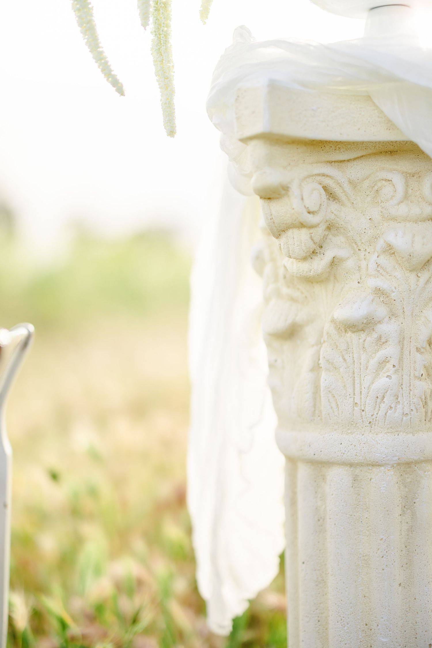 Ornate white decorative pillars with classical details photographed in natural outdoor lighting.