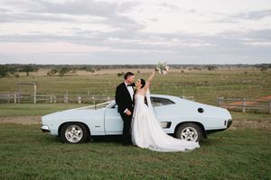 A series of wedding photos showing a couple posing with a classic white sports car in an open field at sunset.