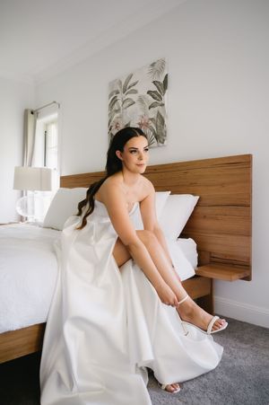 A series of artistic bridal portraits showing a flowing white wedding dress against a wooden headboard.